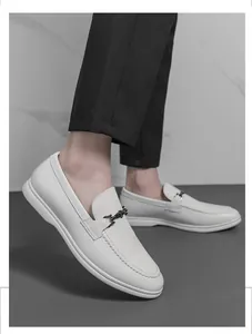 Gros plan de mocassins blancs pour hommes avec boucle métallique élégante