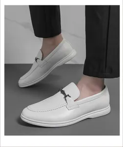 Gros plan de mocassins en cuir blanc pour hommes avec boucle en métal et pantalon noir