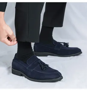 Marineblaue Wildleder-Loafer mit Quasten auf weißem Hintergrund