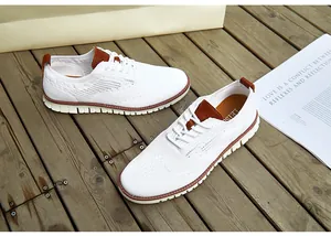 Gros plan de chaussures brogues légères en maille blanche pour hommes sur fond bois