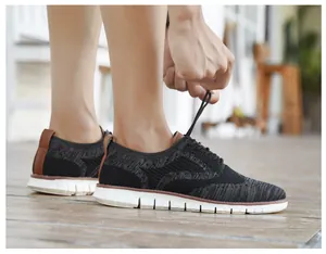 Gros plan de chaussures brogue noires en tricot pour hommes nouées sur un sol en bois