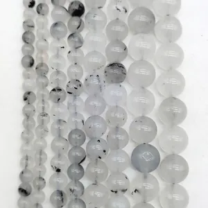 Close-up detail of translucent white gemstone beads with unique black inclusions