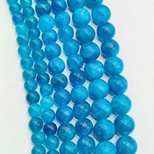 Macro view of vibrant blue loose round gemstone beads with natural ice crackle textures