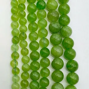Detailed view of multiple strands of natural green jadeite round beads for jewelry making