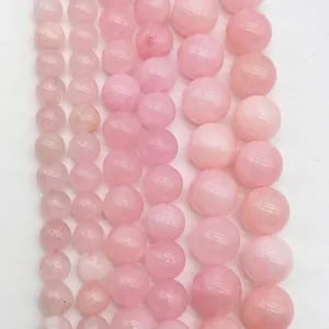 Detailed macro view showing assorted sizes of polished pink lavender amethyst round beads