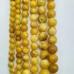 Macro view of polished yellow round loose beads in various sizes for jewelry making