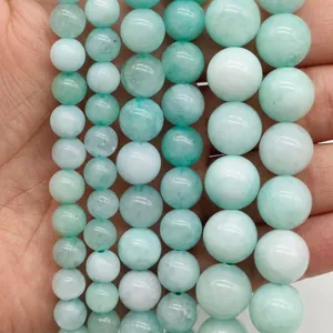Close-up detail of light green gemstone round beads with natural marble texture.