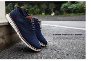 Détail de chaussures brogue en maille bleu marine avec semelle blanche pour hommes.