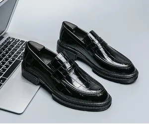Gedetailleerd overzicht van zwarte lakleren loafers met krokodillenmotief en dikke zool