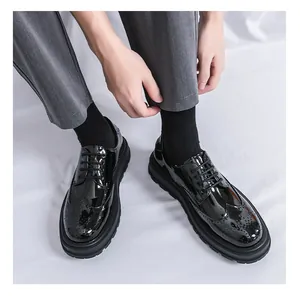 Vista dettagliata di scarpe brogue in vernice nera con suola spessa e coda di rondine.