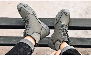 Close-up of trendy men's high-top casual boots with rugged soles on outdoor bench