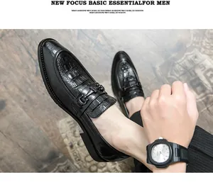 Primer plano de mocasines negros para hombre con textura de cocodrilo y diseño de punta fina.