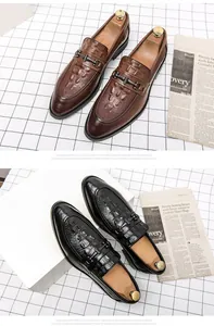 Primer plano de mocasines de cuero con relieve de cocodrilo para hombre en marrón y negro
