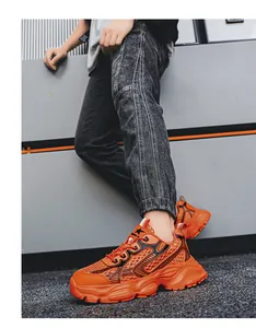 Πλαϊνή όψη των πορτοκαλί chunky mesh sneakers για άνδρες σε αστικό περιβάλλον
