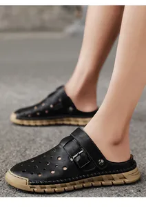 Detail shot of black leather breathable clogs for men with laser-cut holes and buckle strap