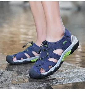 Vista lateral detallada de sandalias de cuero azul para hombre en suelo húmedo exterior