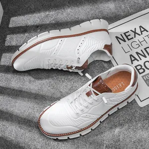 Vue de dessus de chaussures blanches en tricot avec détails en cuir brun sur béton