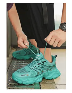 Λεπτομέρεια από τιρκουάζ mesh chunky sneakers με άτομο που δένει τα κορδόνια του