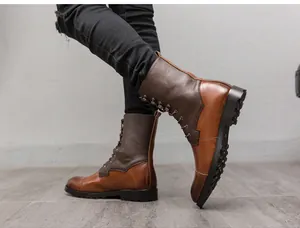 Vista laterale di stivali in pelle marrone bicolore da uomo con jeans neri