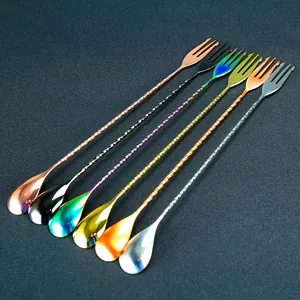 Detailed view of long cocktail mixing spoons with fork ends, stainless steel handles.