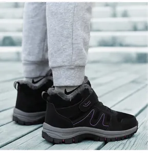 Nahaufnahme von schwarzen, gefütterten Winter-Wanderschuhen, draußen auf Holzdeck