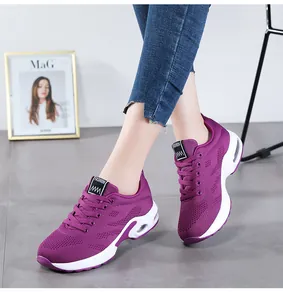 Détail de baskets en mesh fly-knit violettes avec semelles confortables à coussin d'air blanc.