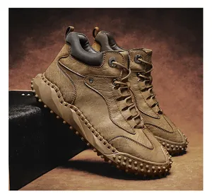 Detail view of men's brown high-top leather boots with rugged lug sole for hiking
