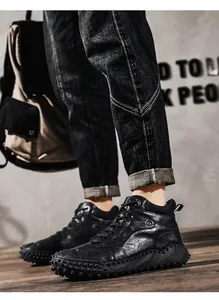 Close-up of men's black leather high-top casual boots with textured soles for hiking and trekking