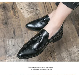 Primer plano de mocasines de cuero negro con borlas, detalles brogue y punta