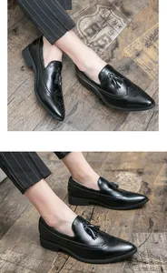 Vista detallada de mocasines de cuero negro con borlas y patrones brogue wingtip