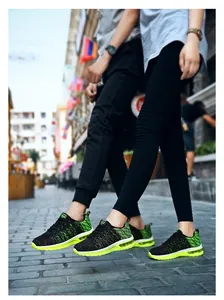 Vue détaillée de chaussures de course en maille respirante noir et vert avec semelles à bulles