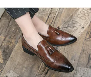 Primer plano de mocasines de cuero marrón con borlas y detalles brogue para hombre