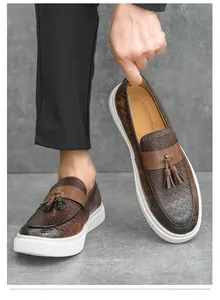 Vista detallada de mocasines marrones para hombre con borlas y textura tejida