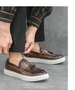 Primer plano de mocasines marrones para hombre con borlas, textura tejida y suelas blancas