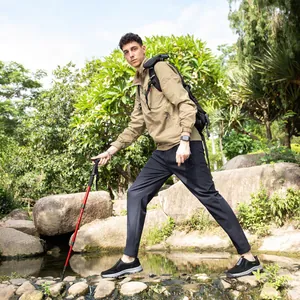 Action shot of men's durable waterproof outdoor shoes while hiking on rocks near a stream