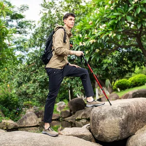 Detail of men's waterproof hiking shoes worn by a model in a natural rocky environment.