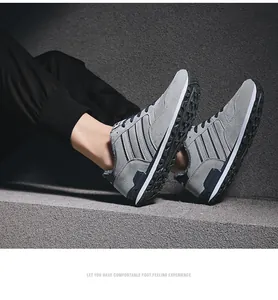 Zapatillas casuales grises para hombre con diseño de rayas sobre fondo de hormigón
