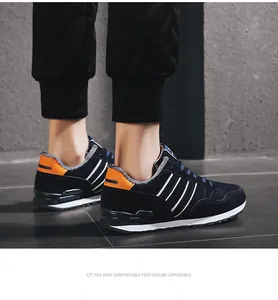 Zapatillas casuales azul marino para hombre con rayas blancas y detalle de talón naranja
