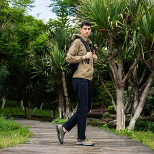 Men's brown waterproof hiking shoes being worn on a wooden garden path outdoors