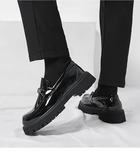 Close-up of black patent leather loafers with thick lug soles worn with black pants