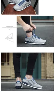 Zapatillas deportivas ligeras grises de hombre con cordones azul marino y rayas de lado