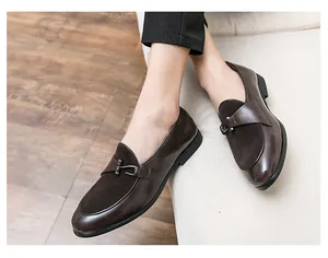 Primo piano di mocassini da uomo marrone scuro in trame di pelle mista.