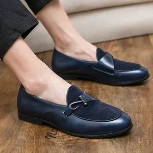 Eleganti mocassini da uomo in pelle blu e camoscio su pavimento in legno