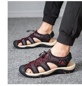 Vue latérale des sandales d'extérieur rouges fly-knit pour hommes sur tapis gris.