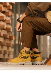 Close-up side view of yellow high-top work boots with camouflage panels and thick soles