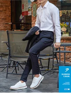 Asiatischer Mann trägt weiße Business-Casual-Brogue-Sneaker in einem Cafè-Außenbereich