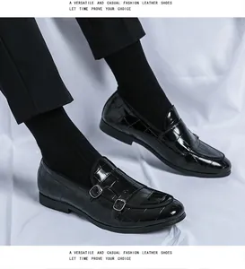 Λεπτομέρεια μαύρα ανδρικά παπούτσια monk strap με ανάγλυφο σχέδιο κροκοδείλου