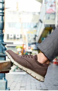 Detaillierte Seitenansicht eines braunen Herren-Sneakers mit dicker cremefarbener Sohle.