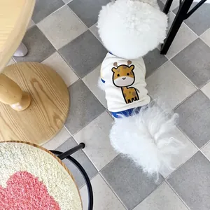 Detailed view of cream-colored dog vest with a cute cartoon giraffe print on a fluffy pet