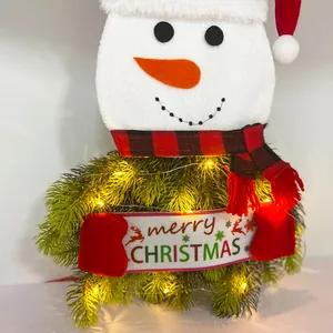 Detailed view of a festive Christmas snowman tree topper decoration with warm LED fairy lights